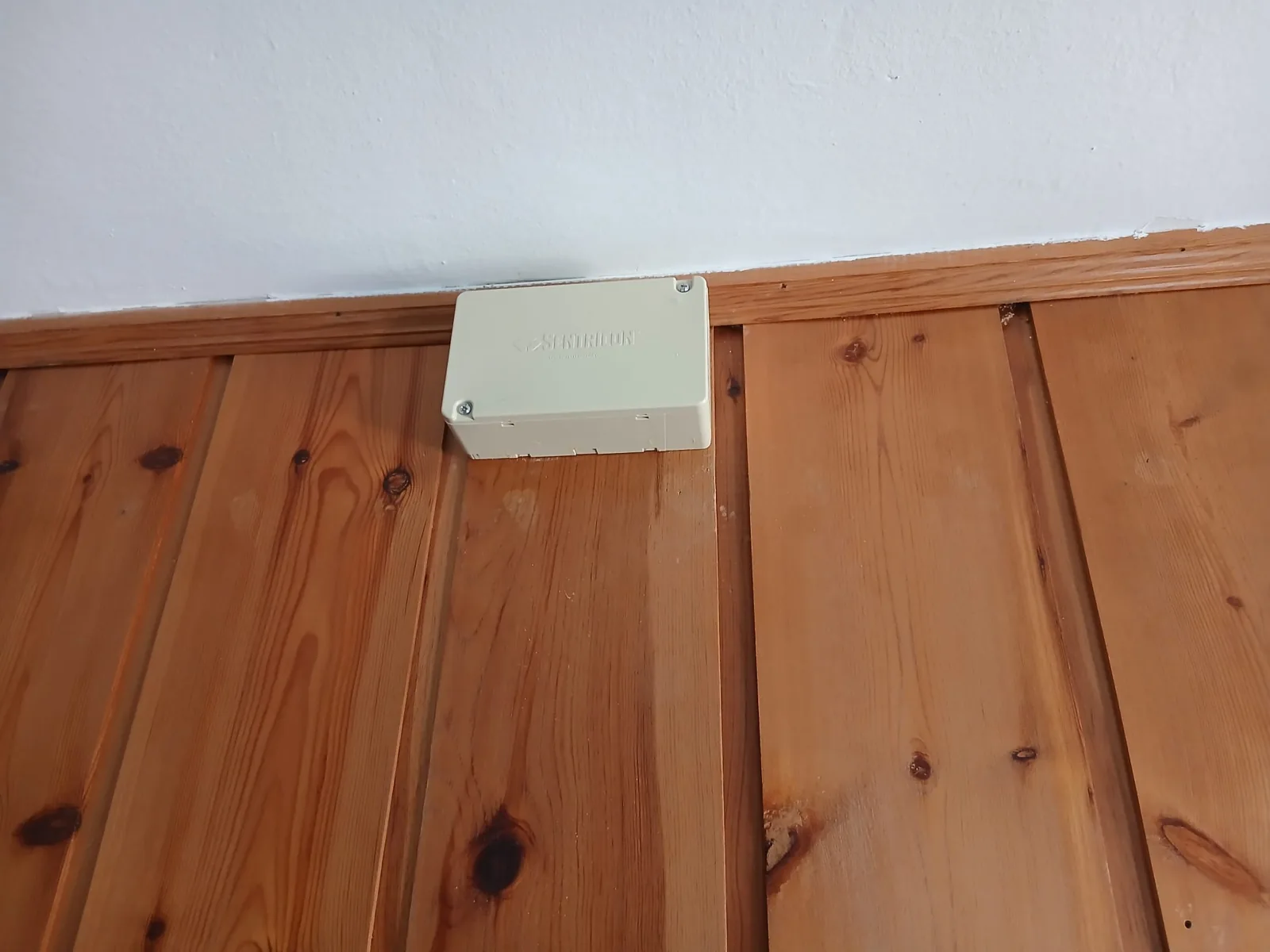Caja Sentribox instalada sobre el friso interior de madera.